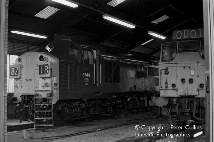 Sniffing the East London air from inside one of Stratford Motive Power Depot’s maintenance sheds are two typical stalwarts of 1960s and 1970s Great Eastern Division train working; a Syphon and a Ped. In the mid 1970s, a Class 37 Type 3 number 6744 shares cover with a Class 31 Type 2. One of the lights needs attention in the nose of the Type 3, which seems to be recently ex-works, although Stratford did a lot of loco work themselves including complete paint jobs. In contrast the Type 2 has obviously not seen much cosmetic care for some time in line with the majority of its class-mates.